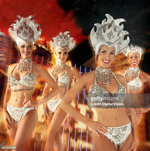 four chorus girls, against a blurred composite background of neon lights - show girl stock pictures, royalty-free photos & images