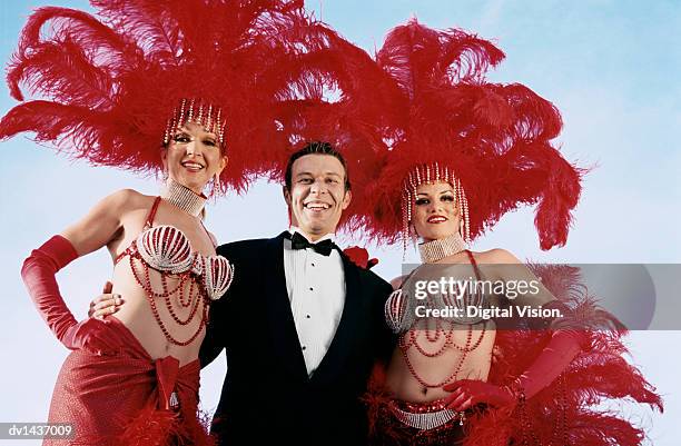 man wearing a dinner jacket with his arm around showgirls - chorus line stock-fotos und bilder