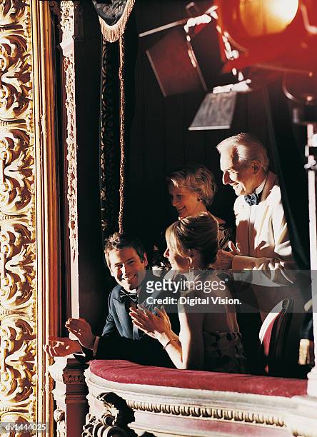 mature and young couples appluading in a theatre balcony - applauding balcony stock pictures, royalty-free photos & images