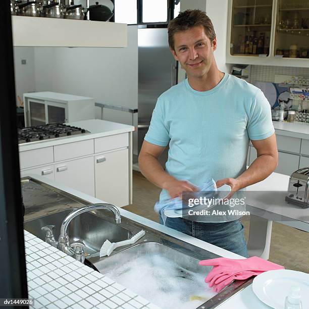 man drying a plate in a kitchen - kitchen-sink-top-view stock pictures, royalty-free photos & images