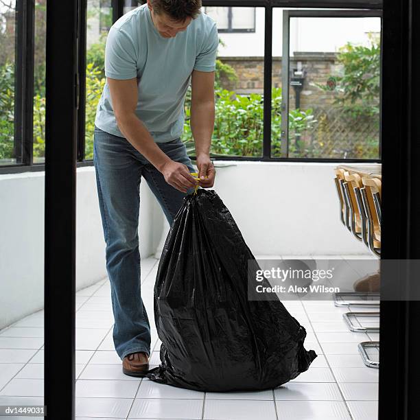 man in the home tying a bin bag - man tied to chair stockfoto's en -beelden