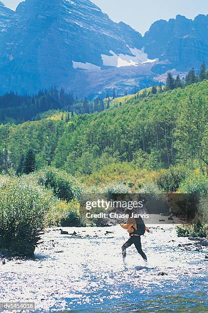 young woman walking through water in a scenic landscape, maroon bells, aspen, colorado, usa - maroon bells summer stock pictures, royalty-free photos & images