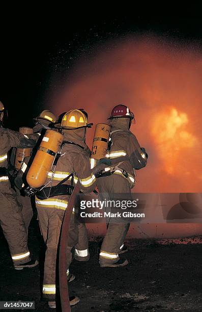 fireman putting out a fire - gibson stock pictures, royalty-free photos & images
