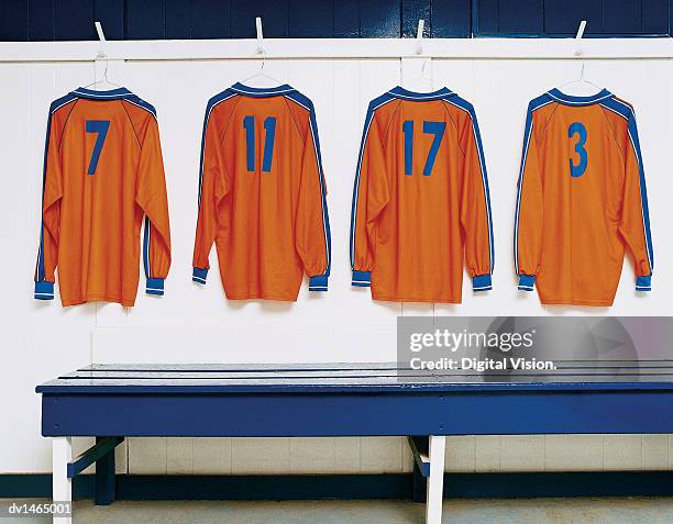 four sports strips hanging in a changing room - tenue de football photos et images de collection