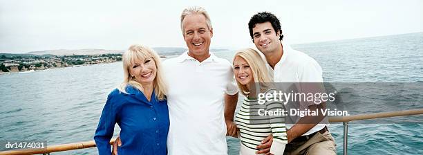 mature couple stand with their son and daughter-in-law on the deck of a boat - daughter in law stock pictures, royalty-free photos & images