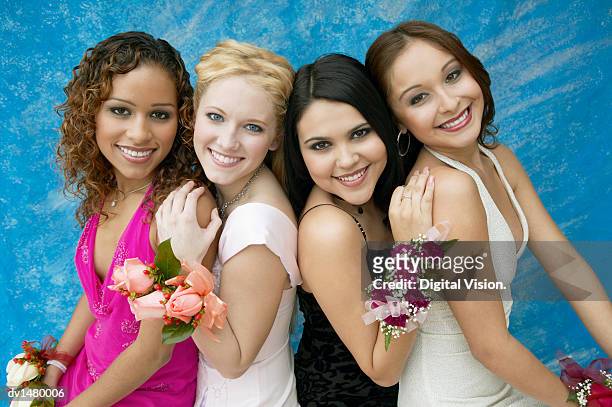 portrait of four girls wearing evening dresses and corsages - prom stock pictures, royalty-free photos & images