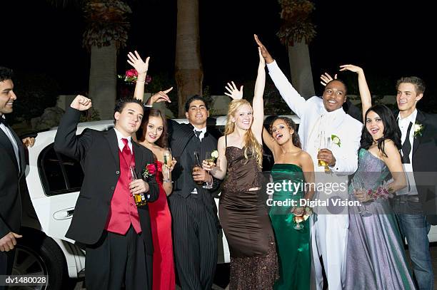 teenage boys and girls standing in front of a limousine dressed for their high school prom - proms stock-fotos und bilder