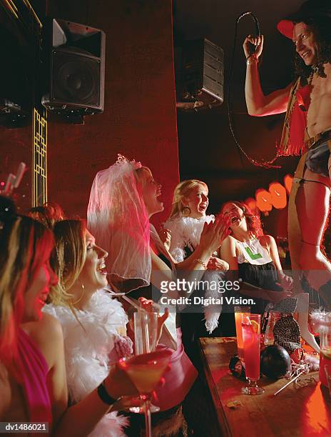 male stipper dressed as a cowboy, performing for a group of women on a hen night - stipper stock pictures, royalty-free photos & images