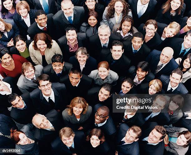 large group of business people standing and looking up at camera - grande gruppo di persone foto e immagini stock