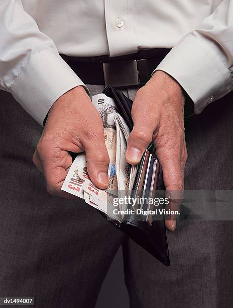 close up of a man holding a wallet containing british ten pound banknotes - ten pound note ストックフォトと画像