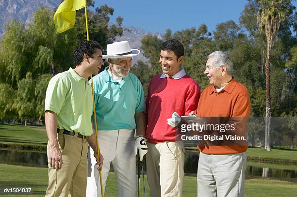 fathers with their sons on a golf course - four people stock pictures, royalty-free photos & images