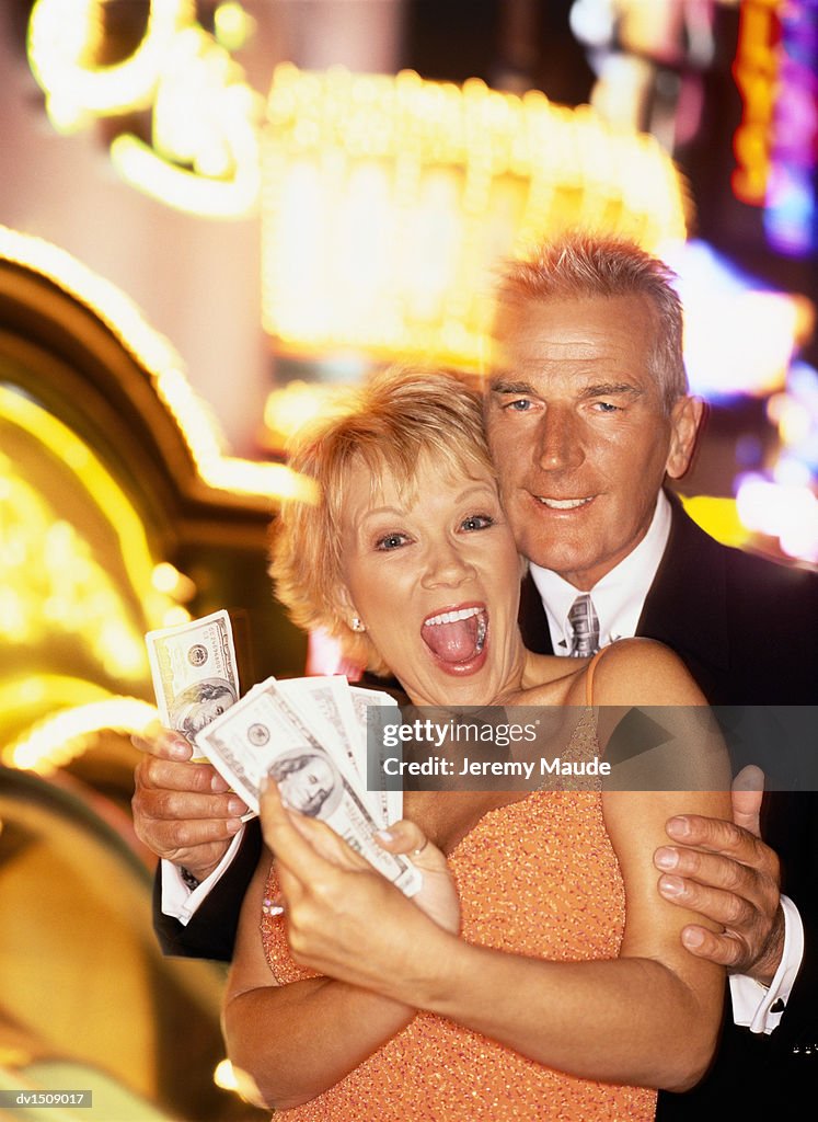 Mature Couple Showing US Dollar Banknotes Outside a Casino