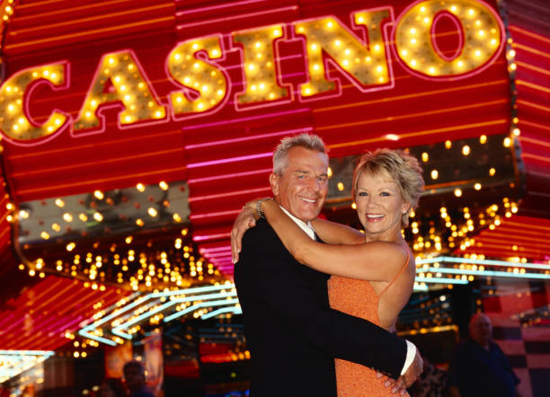 smiling, mature couple cuddling in front of a casino - las vegas casino photos et images de collection