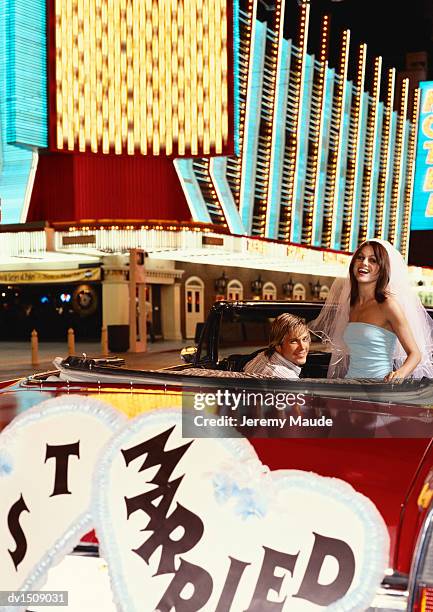 young newlywed couple driving in a classic car in the streets of las vegas, usa - las vegas wedding stock pictures, royalty-free photos & images