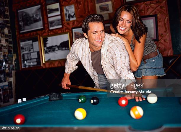 couple playing pool in a bar - bending over in skirt stock-fotos und bilder
