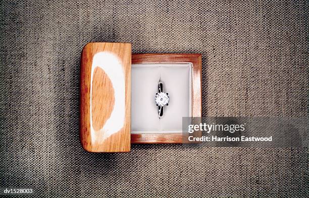 overhead shot of an engagement ring in a jewellery box, on a fabric surface - harrison wood stock pictures, royalty-free photos & images