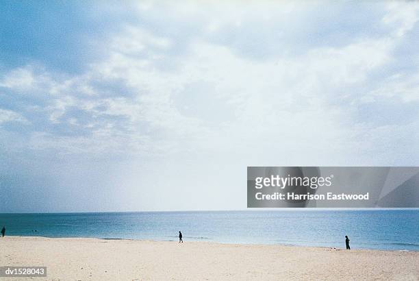 distant people walking on an empty beach in the sardina region of pula - region stock pictures, royalty-free photos & images