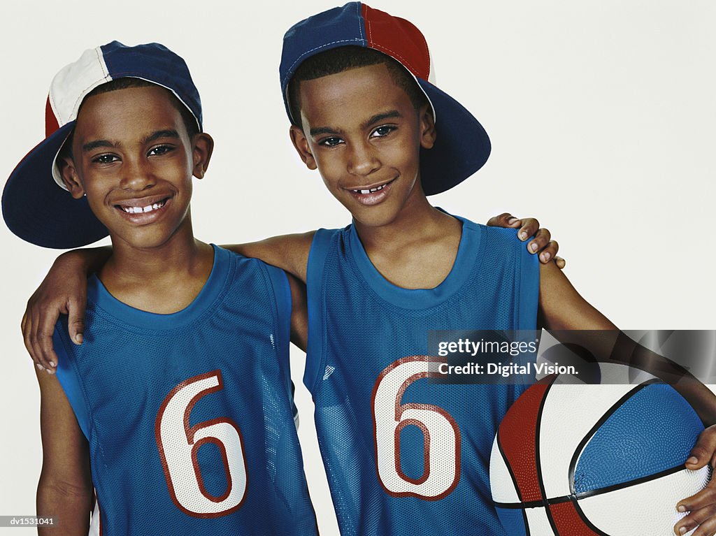 Studio Portrait of Twin Brothers in Sports Strips With Arms Around Each Other