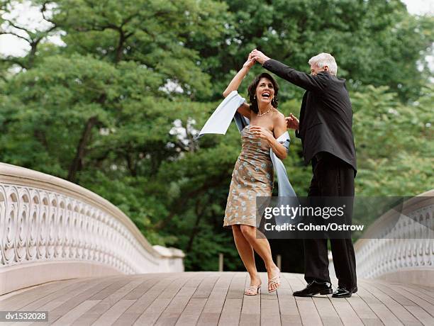 senior couple dancing on bow bridge, central park, new york city, usa - abendkleid stock-fotos und bilder