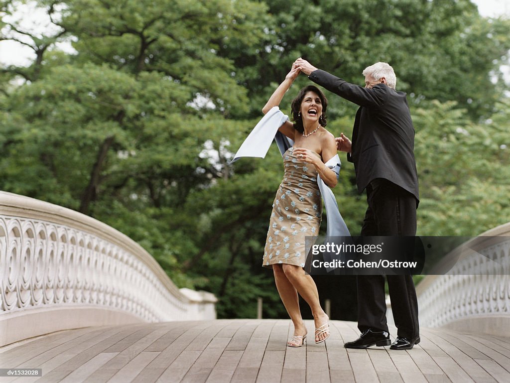 Senior Couple Dancing on Bow Bridge, Central Park, New York City, USA