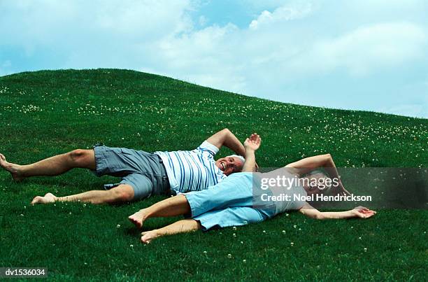 elderly couple rolling down a hill - de rola imagens e fotografias de stock