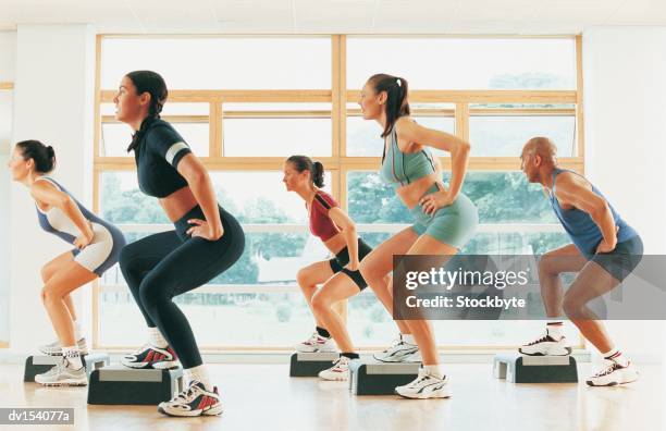 three women in step workout class doing lateral lunges - lateral stock pictures, royalty-free photos & images