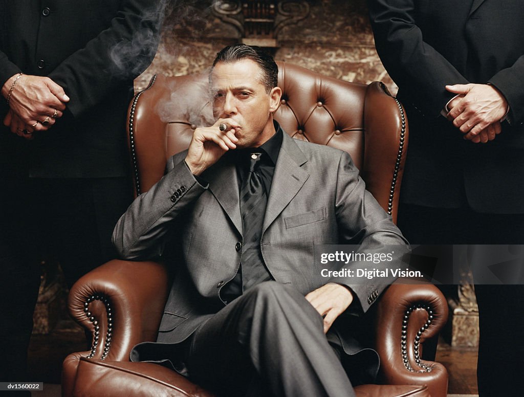 Wealthy Criminal Sitting in an Armchair Between two Bodyguards