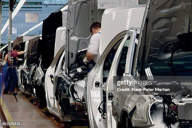 men working on a car assembly line in a factory - installation of memorial honors victims of ghost ship fire in oakland stockfoto's en -beelden