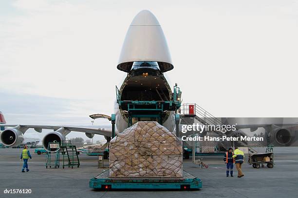 payload being loaded onto a cargo plane - frachtflugzeug stock-fotos und bilder