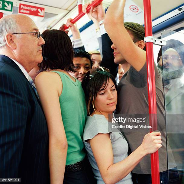 group of adults stands uncomfortably crowded onto a passenger train - busy photos et images de collection