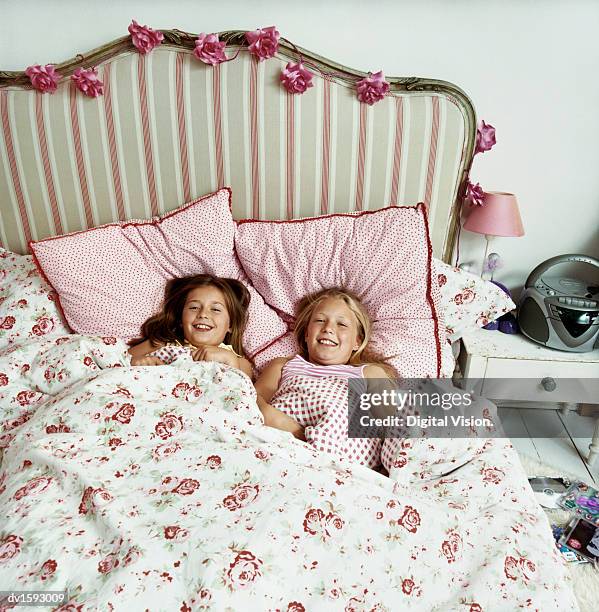 two girls lying side by side in bed - bedroom radio bildbanksfoton och bilder