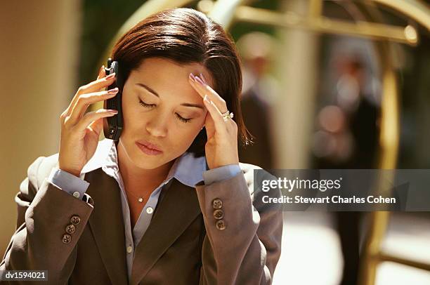 young business woman, using a mobile phone and looking stressed - stewart stock-fotos und bilder