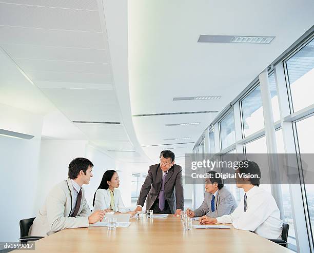 group of businesspeople planning strategy all looking at one man - all stock pictures, royalty-free photos & images