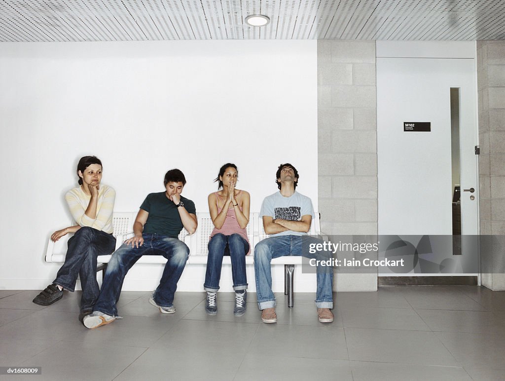 Four Young Students Sat in a Line, Looking Nervous