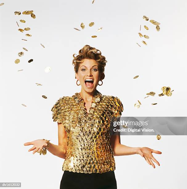 woman wearing a top made of golden coins, coins falling on her - coins falling stock-fotos und bilder