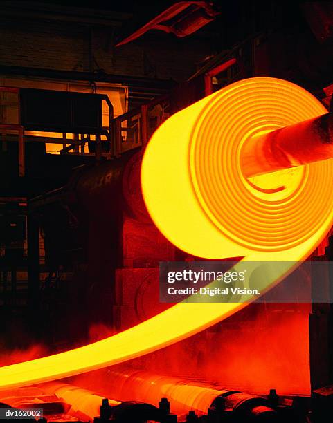 red-hot roll of steel in steel mill - siderurgicas fotografías e imágenes de stock