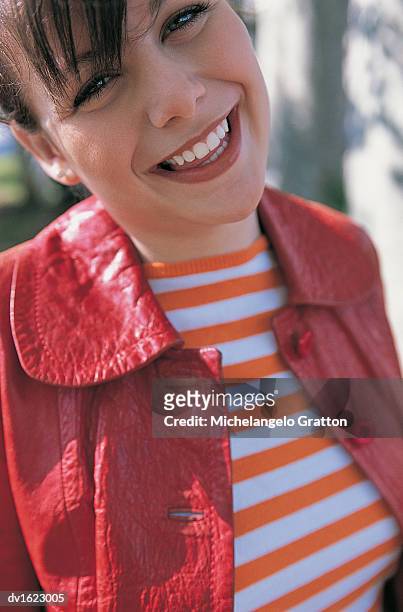 young woman in a striped top and a red leather jacket smiles at the camera - wonky fringe stock pictures, royalty-free photos & images