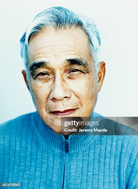 studio portrait of an elderly man in a blue jumper - only japanese stock pictures, royalty-free photos & images