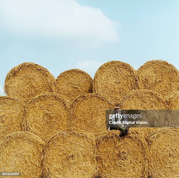 farmer relaxing on hay bales, looking at the camera - gestalt stock pictures, royalty-free photos & images