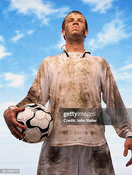 low angle view of a sweaty football player covered in mud - football player imagens e fotografias de stock