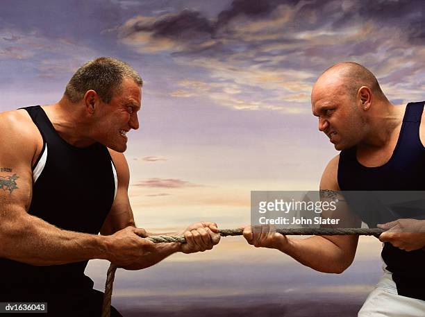 two men competing against each other in a tug of war - war stock-fotos und bilder