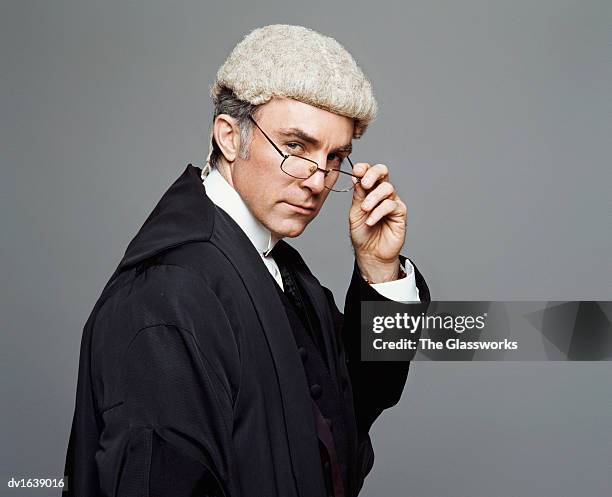 portrait of a lawyer in wig and robe looking over his spectacles - túnica fotografías e imágenes de stock