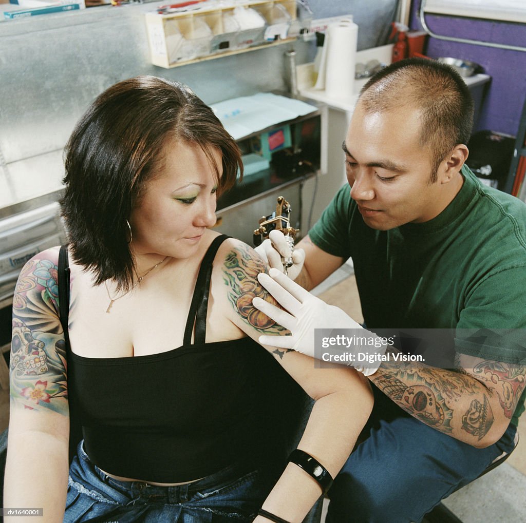 Tattooist Tattooing a Woman's Arm