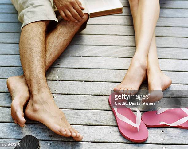 low section shot of couple lying on decking - barefoot outside stock pictures, royalty-free photos & images