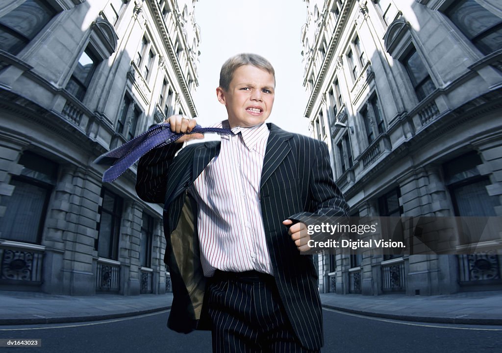 Boy Dressed as a Businessman Looking Stressed and Removing his Tie