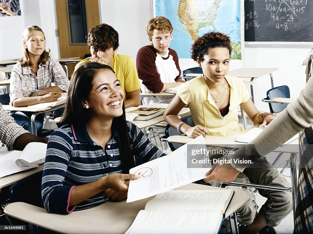 A Student is Given Back her Exam Results, While Members of the Class Look on