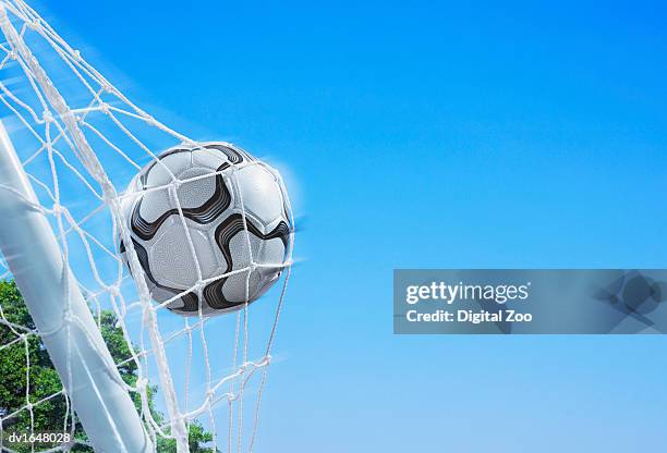 football in a net against a blue sky - goal sports equipment fotografías e imágenes de stock