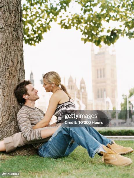 couple gazing at each other under a tree near the houses of parliament, london - vigils are held for the victims of the london bridge terror attacks stockfoto's en -beelden