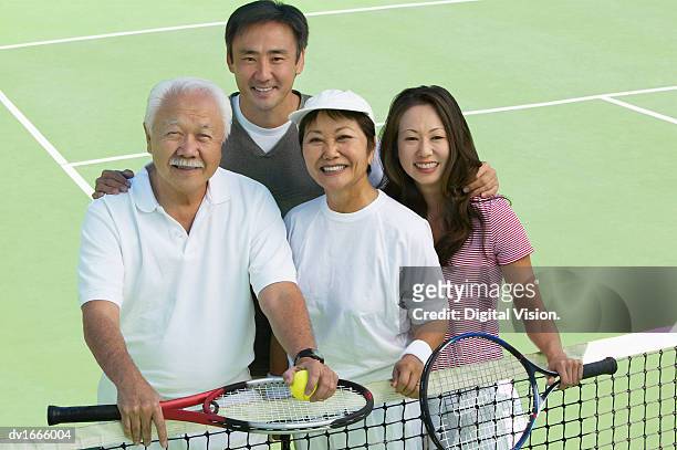 portrait of a family standing together on a tennis court - japanese tennis stock pictures, royalty-free photos & images
