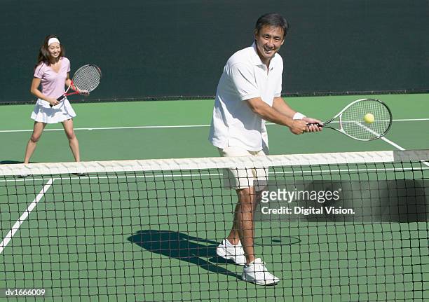 man and woman playing tennis together on a court - japanese tennis stock pictures, royalty-free photos & images
